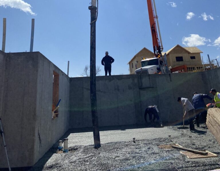 Workers Pouring Foundation Slab With Pump Truck